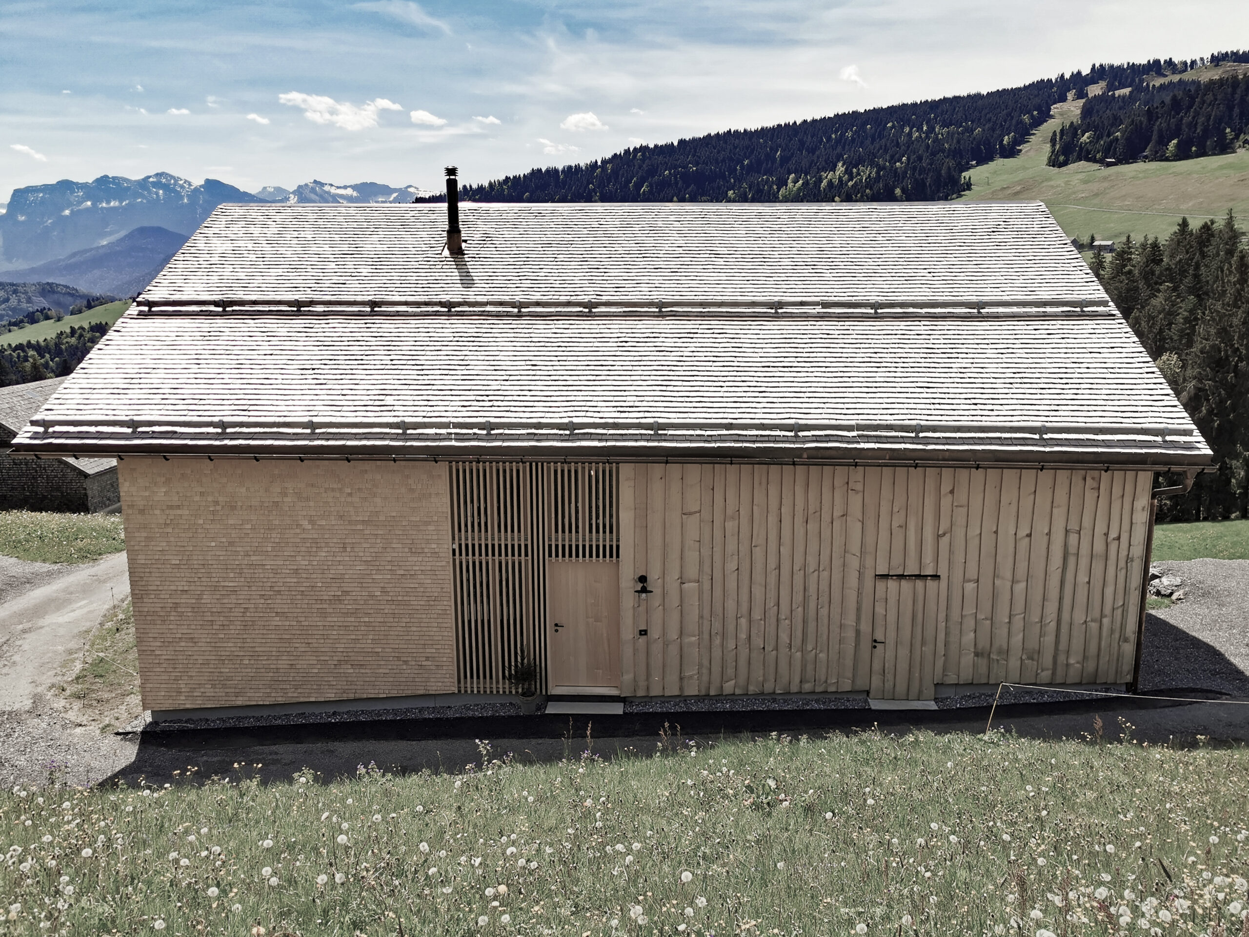 Holzhaus mit Schindeln und Schirm