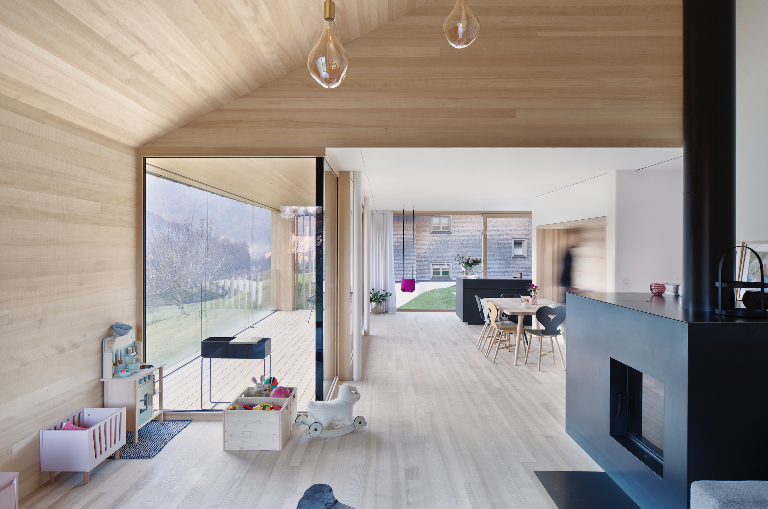 Offenes Wohnzimmer aus Holz mit schwarzem Stahloffen