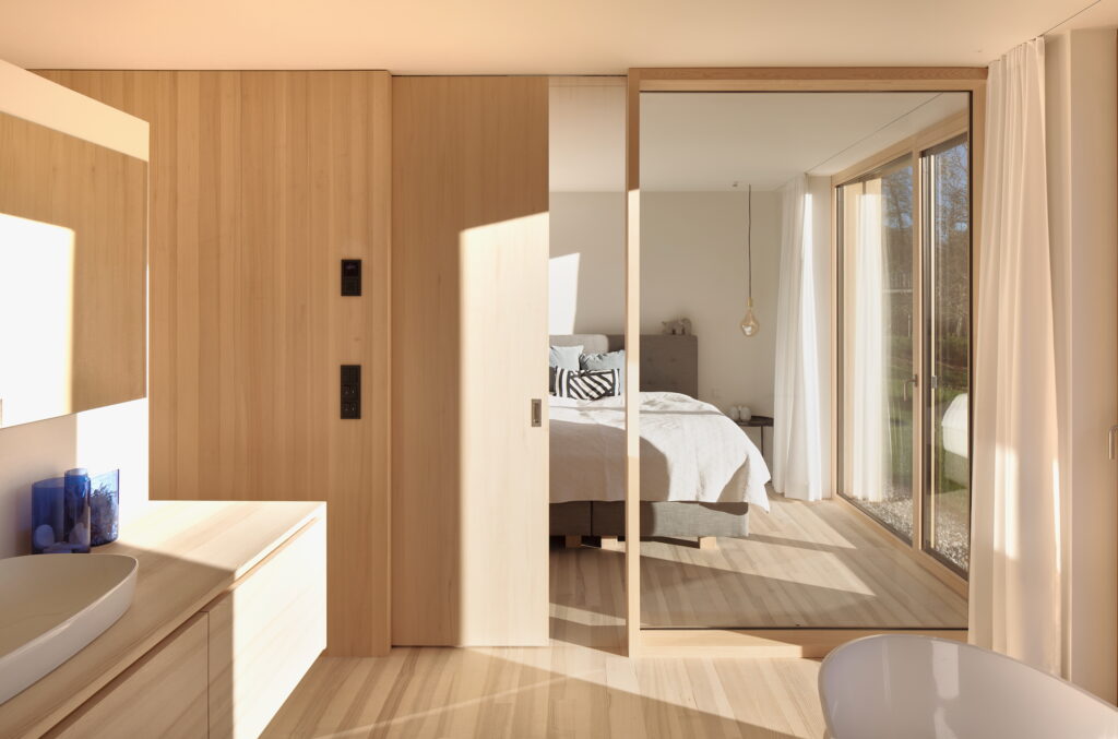 Helles Badezimmer mit Blick auf angrenzenden Schlafzimmer